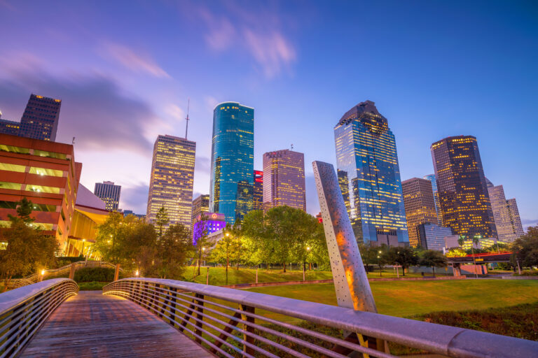 The vibrant hues of twilight cast a serene glow over the Downtown Houston skyline, captured in this stunning stock photo.