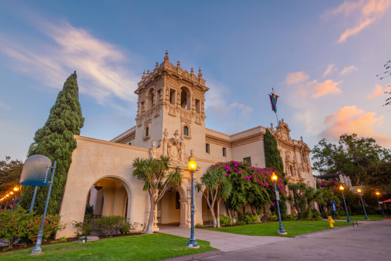 The warm glow of sunset bathes the historic architecture of San Diego’s Balboa Park, highlighting its beauty and serene ambiance.