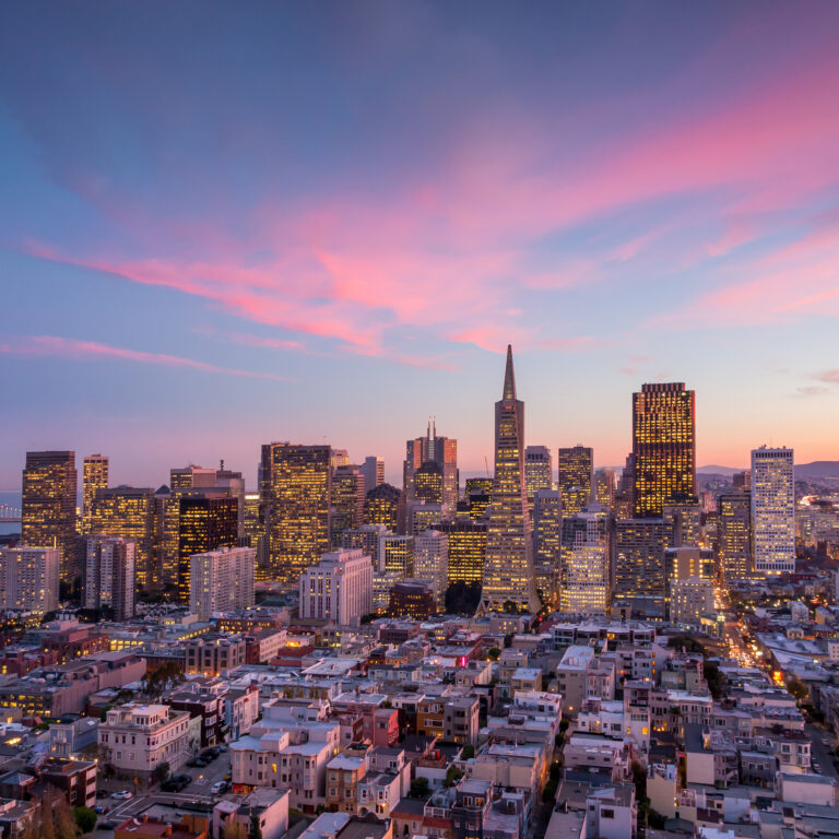 The San Francisco skyline basks in the warm glow of a stunning sunset, painting the city in a tapestry of vibrant hues.