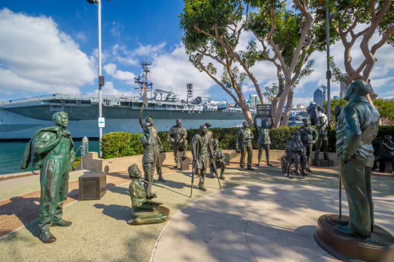Bronze statues pay tribute to Bob Hope and the military, capturing a moment of entertainment and camaraderie with the USS Midway in the background.