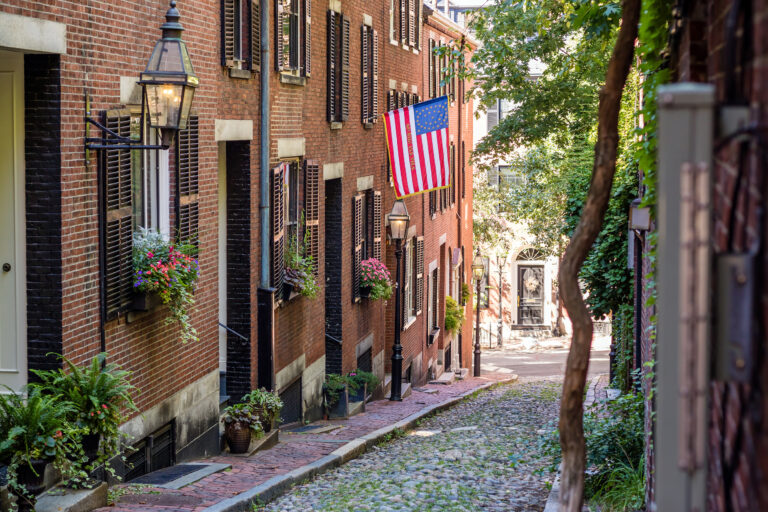 Stroll down the charming cobblestone path of Acorn Street in Boston, where American history is etched in every brick and blooming window box.