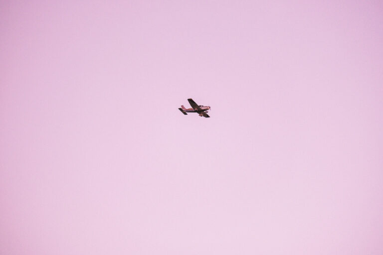 A solitary aircraft soars against the soft hues of a San Diego sky, encapsulating the serene essence of flight.